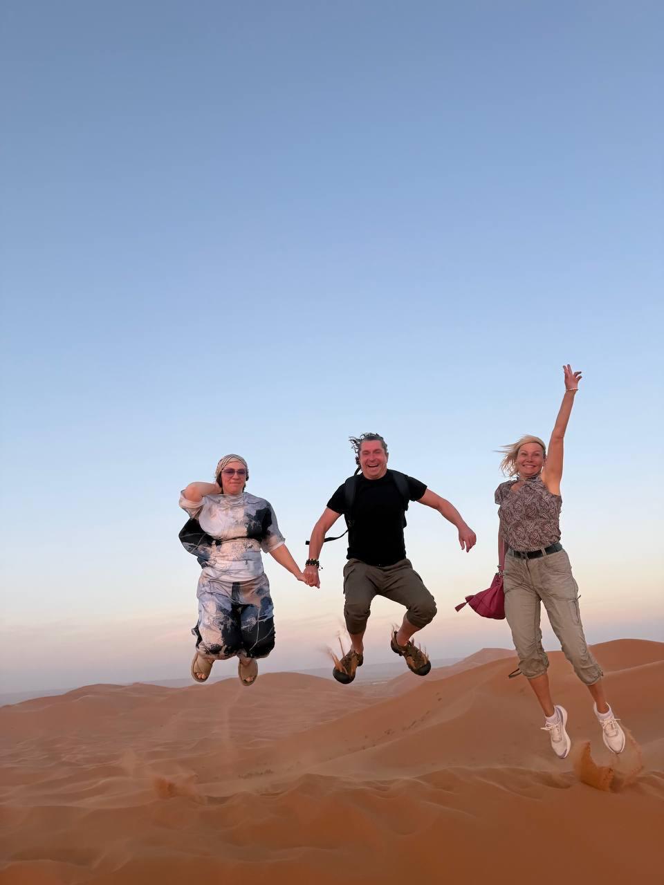 Guests jumping on desert dunes